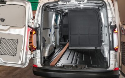VW Transporter mit L-Trennwand: zwei Sitze im Fond, dahinter und daneben Platz für Fracht.