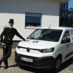 Schmucker Schornsteinfedermeister, eher schlichter Citroen E-Berlingo.